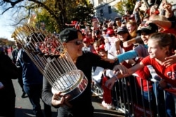 Washington Nationals General Manager Mike Rizzo shows off the World Series trophy to cheering fans during a parade to celebrate the team's World Series baseball championship over the Houston Astros, Nov. 2, 2019, in Washington.