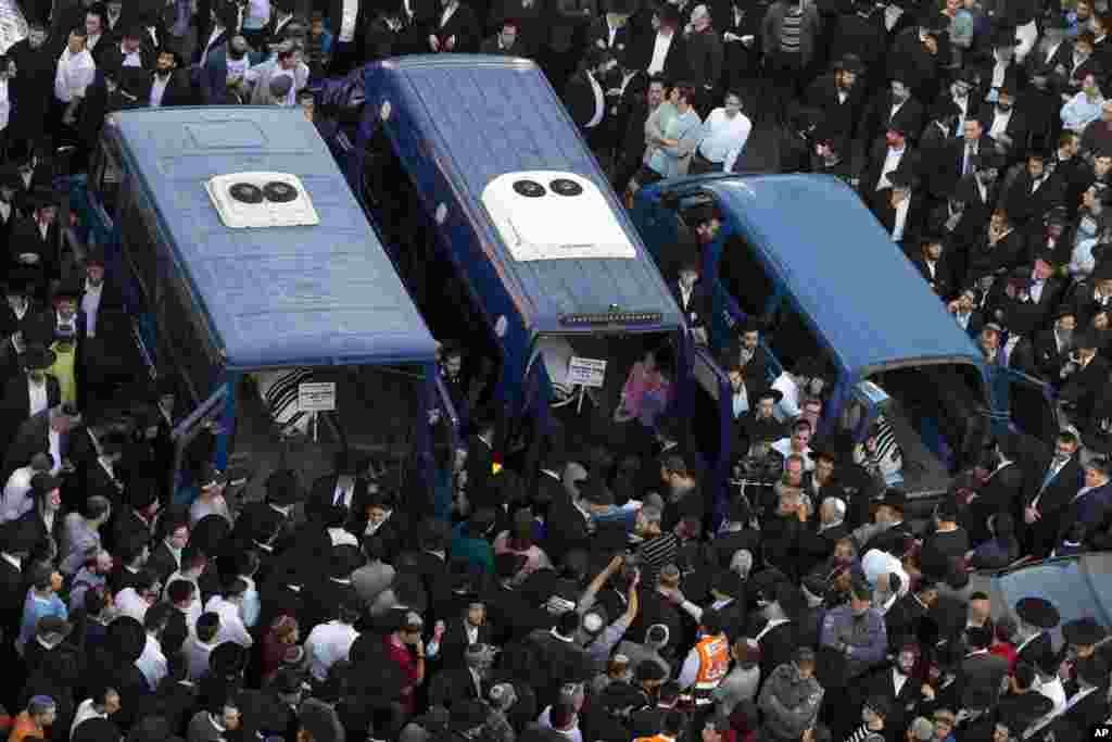 Mourners attend the funerals of Aryeh Kupinsky, Cary William Levine, and Avraham Goldberg, three of the four people killed in a shooting attack in a synagogue in Jerusalem.