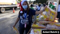 Lorena es una voluntaria que ayuda regularmente en la distribución de alimentos en varios centros de Miami, Florida. Foto: Antoni Belchi / VOA.