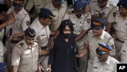 Indian policemen escort political cartoonist Aseem Trivedi, center in black as they leave a court in Mumbai, India, Monday, Sept. 10, 2012.