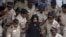 Indian policemen escort political cartoonist Aseem Trivedi, center in black as they leave a court in Mumbai, India, Monday, Sept. 10, 2012.