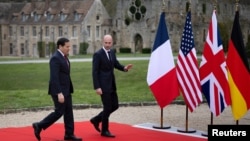 پرچم‌های آلمان، بریتانیا، آمریکا، و فرانسه در پس‌زمینه تصویری از وزیران خارجه ایالات متحده و فرانسه در حاشیه دیدار وزیران خارجه گروه هفت در فرانسه 