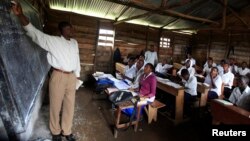 FILE - A teacher conducts a mathematics lesson to high school students in Democratic Republic of Congo town of Bunagana, Oct. 19, 2012. Many teachers are paid months late.
