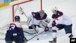 Kiper tim hoki es Amerika Jonathan Quick (tengah) dan rekan setimnya, John Carlson (nomor 4), saat berhadapan dengan pemain Slovakia Zdeno Chara (nomor 33) dalam Olimpiade Musim Dingin 2014 di Shayba Arena, Sochi, Rusia (13/2). USA berhasil mengalahkan Slovakia 7-1 dalam pertandingan ini. (AP Photo/Matt Slocum)