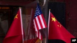 Bendera nasional Tiongkok dan AS terlihat dipajang di luar sebuah toko suvenir di Beijing pada 31 Januari 2025. (Foto: AP)