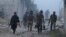 Rebel fighters from the Islamic Front walk amidst smoke during what they said was an offensive against forces loyal to Syria's President Bashar al-Assad in Maarat Al-Nouman, Idlib province, May 5, 2014. 