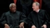 Hakim Mahkamah Agung AS Clarence Thomas (kiri) berbicara dengan hakim ketua John Roberts dalam sebuah kesempatan di gedung Mahkamah Agung di Washington, pada 30 November 2018. (Foto: Jim Young)