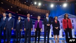 Democratic presidential hopefuls, from left, Bill de Blasio, Tim Ryan, Julian Castro, Cory Booker, Elizabeth Warren, Beto O'Rourke, Amy Klobuchar and Tulsi Gabbard arrive to the first Democratic primary debate in Miami, June 26, 2019.