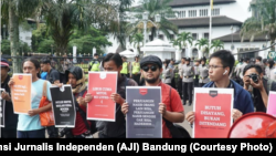 Sejumlah jurnalis mengangkat poster dalam aksi Hari Buruh di Bandung, 1 Mei 2019. Dalam aksinya, mereka menuntut kesejahteraan wartawan dan penghapusan kekerasan terhadap awak media. (Foto: Aliansi Jurnalis Independen (AJI) Bandung)