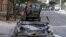 Men rest at the back of a pickup truck near a damaged car in the rebel held al-Katerji district in Aleppo, Syria, Aug. 13, 2016. 