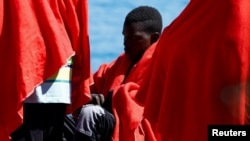 Un migrante espera ser atendido por la Cruz Roja después de desembarcar de un buque guardacostas español en el puerto de Arguineguin, en la isla de Gran Canaria, España, el 27 de septiembre de 2024. 