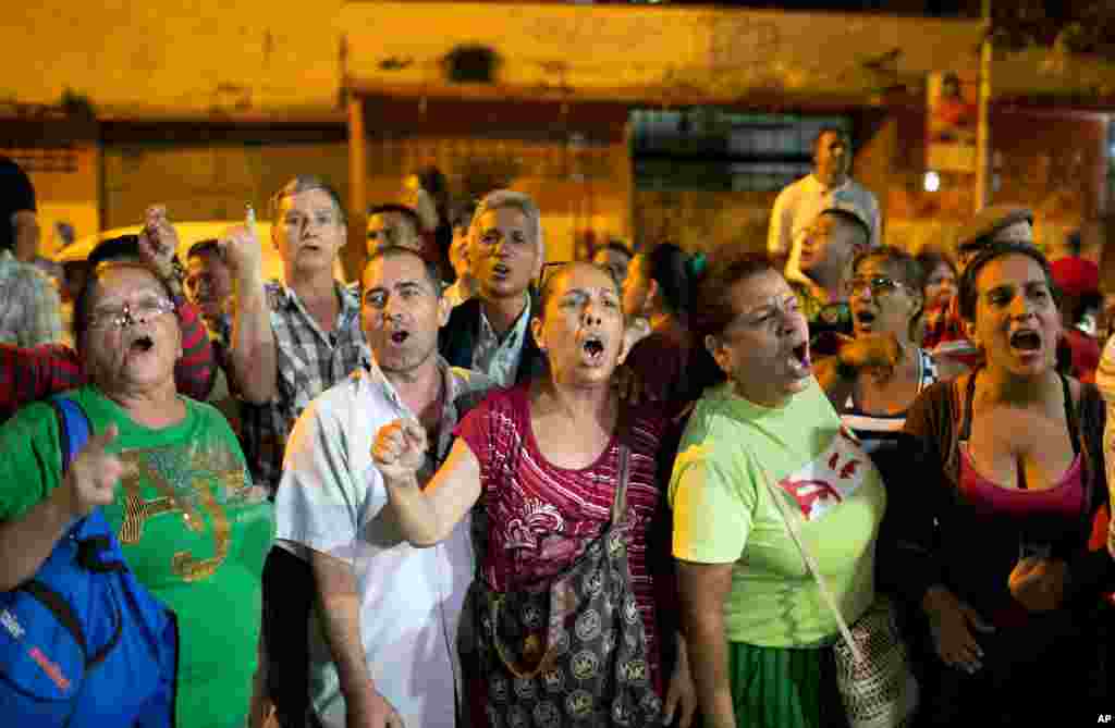 Pro-government supporters demand that a polling station in Caracas reopen after its official closing.