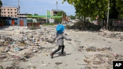 A pedestrian walks along a street in downtown Port-au-Prince, Haiti, on Sept. 23, 2024. Prime Minister Garry Conille said on Sept. 25 that Haiti is far from winning its war against the gangs that control a large part of the capital, Port-au-Prince.