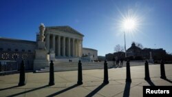 The sun casts shadows as it rises over the U.S. Supreme Court in Washington, U.S., December 20, 2023.