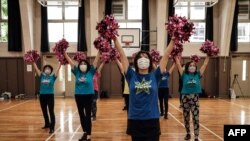 Anggota regu pemandu sorak senior Jepang "Japan Pom Pom" sedang berlatih di Tokyo, 26 Juli 2021. (Yasuyoshi CHIBA / AFP)