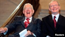 FILE - Northern Ireland's new first minister Ian Paisley (L) and deputy first minister Martin McGuinness smiling after being sworn in at a ceremony at Stormont, Belfast, Ireland, May 8, 2007.