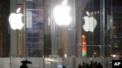 Pedestrians pass the Apple store location on Fifth Avenue in New York, June 6. 