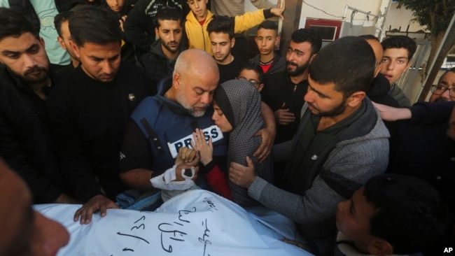El periodista de Al Jazeera, Wael Dahdouh, toma la mano de su hijo Hamza, quien también trabajaba para Al Jazeera y murió en un ataque aéreo israelí en Rafah, Franja de Gaza, el domingo 7 de enero de 2024.