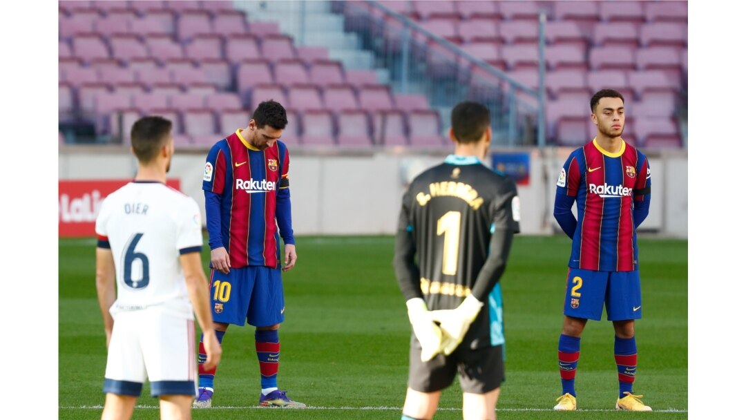 Los jugadores del FC Barcelona y Osasuna guardan un minuto de silencio en memoria de Diego Armando Maradona antes del inicio del partido de fútbol de la Liga española en el estadio Camp Nou de Barcelona, España, el domingo 29 de noviembre de 2020.