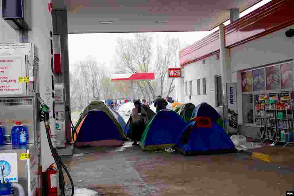 Beberapa ratus pengungsi berkemah di sebuah pom bensis 18 kilometer dari kamp Idomeni.&nbsp;(VOA/Jamie Dettmer)