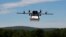 FILE - A prototype drone is seen carrying a parcel for delivery.