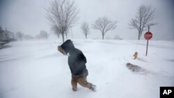 Cassie Peterson camina entre la nieve durante la más reciente tormenta invernal en Portland, Maine, el martes, 13 de marzo de 2018.