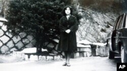 In this undated photo released Nov. 17, 2004, by the Tokyo-based National Association for the Rescue of Japanese Kidnapped by North Korea, Megumi Yokota stands by a car at an unknown place in North Korea after her abduction from her hometown in Japan. 