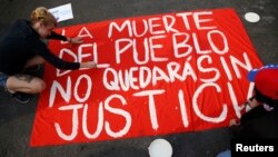 Manifestantes muestran un cartel que clama por justicia durante una protesta contra el gobierno.