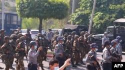 Armed soldiers and police move in during a demonstration against the military coup in Mawlamyine in Mon State on February 12, 2021. (Photo by STR / AFP)