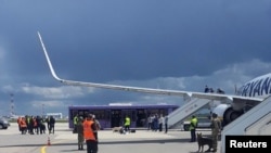 FILE - Airport personnel and security forces are seen on the tarmac in front of a Ryanair flight which was forced to land in Minsk, Belarus, May 23, 2021.