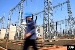 FILE - A worker walks past the sub-station at a crypto mining plant in Hernandarias, 350km east of Asuncion, Paraguay on August 2, 2024. (Photo by DANIEL DUARTE / AFP)