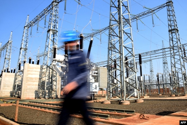 FILE - A worker walks past the sub-station at a crypto mining plant in Hernandarias, 350km east of Asuncion, Paraguay on August 2, 2024. (Photo by DANIEL DUARTE / AFP)