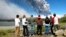 FILE - Local residents watch a column of smoke and ash rise from the Copahue volcano, located on the Chile-Argentina border, December 22, 2012. 