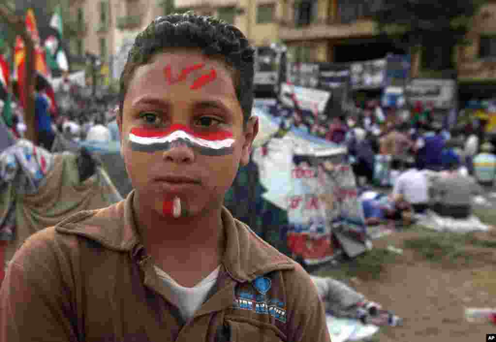 A young protester in Tahrir Square, his face painted with the word &quot;Morsi.&quot;