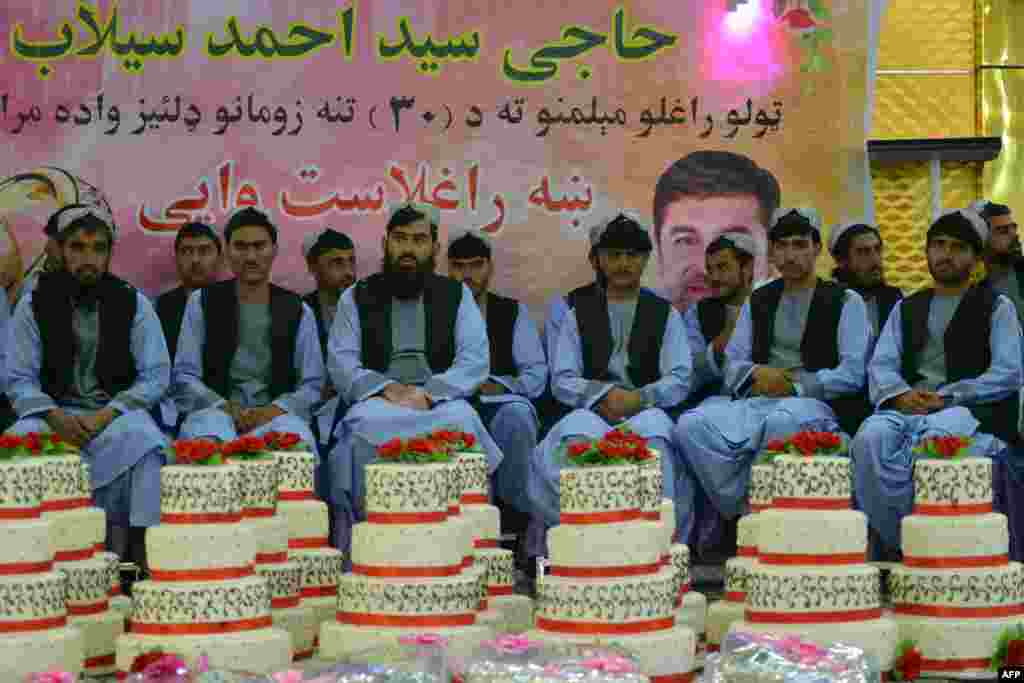 Grooms sit inside a wedding hall as they wait for the start of a mass marriage ceremony organized by the Selab Charity Foundation in Kandahar.