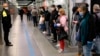 People stand apart from each other as they wait for a subway train in Rome, Italy, April 27, 2020.