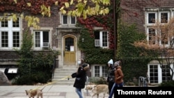 People walk their dogs on the campus of the University of Wisconsin-Madison as the coronavirus disease (COVID-19) outbreak continues in Madison