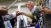 Corporate recruiters (R) gesture and shake hands as they talk with job seekers at a Hire Our Heroes job fair targeting unemployed military veterans and sponsored by the Cable Show, a cable television industry trade show in, Washington, June 11, 2013.