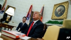 President Donald Trump speaks with reporters about allowing the release of a secret memo on the F.B.I.'s role in the Russia inquiry, during a meeting with North Korean defectors in the Oval Office of the White House, Feb. 2, 2018, in Washington.