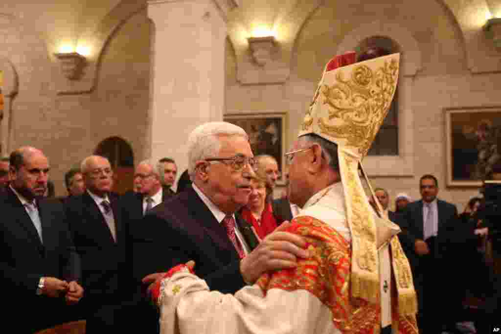 Palestinian President Mahmoud Abbas is welcomed by Latin Patriarch of Jerusalem Fouad Twal at the Church of the Nativity in the West Bank town of Bethlehem, Dec. 25, 2013.