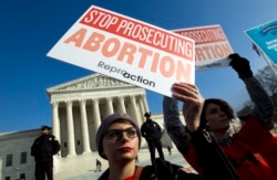 FILE - Abortion rights activists protest outside the U.S. Supreme Court, during the March for Life in Washington, Jan. 18, 2019.