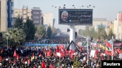 Warga Iran yang berduka, mengikuti prosesi pemakaman komandan militer Qassem Soleimani, di kota kelahirannya di Kerman, Iran, 7 Januari 2020.