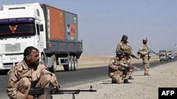 Private security contractors guard a part of a route as NATO supply trucks drive past in the province of Ghazni, south-west of Kabul, Afghanistan, 27 Oct 2010.