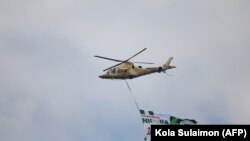 Un hélicoptère de l'armée de l'air nigériane survole Abuja, au Nigeria, lors de la célébration du 60e anniversaire de l'indépendance du pays, le 1er octobre 2020. 