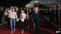 Fotografija ruske državne agencije Sputnjik, ruski predsednik Vladimir Putin pozdravlja državljane Rusije oslobođene u velikoj razmeni zatvorenika sa Zapadom, 1. avgusta 2024. (Foto: Kiril ZIKOV / POOL / AFP)