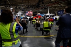 People listen as President Donald Trump speaks at Ford's Rawsonville Components Plant that has been converted to making personal protection and medical equipment, in Ypsilanti, Mich., May 21, 2020.