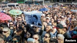 FILE - People queue to pay respect during the memorial service before the funeral of assassinated Kazakhstan's Olympic figure skater Denis Ten in Almaty, Kazakhstan July 21, 2018. 