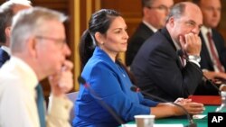 FILE - Britain's Home Secretary Priti Patel, center, attends a Cabinet meeting of senior government ministers at the Foreign and Commonwealth Office in London, Sept. 1, 2020.