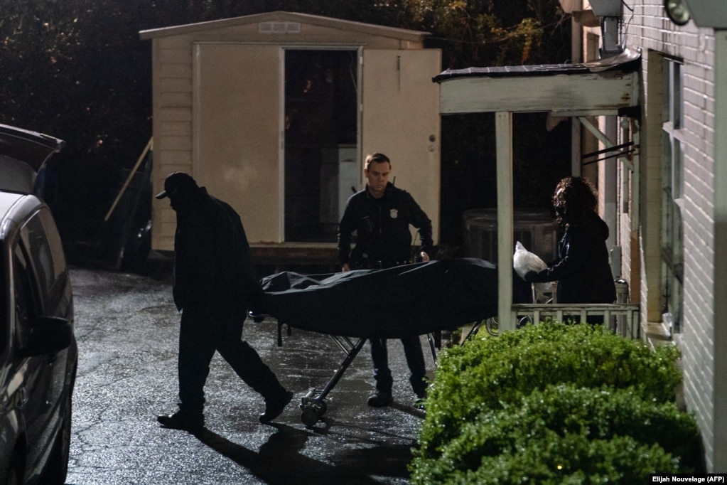 Le personnel du médecin légiste sort un corps sur une civière d'un salon de massage où trois personnes ont été tuées par balle le 16 mars 2021 à Atlanta, en Géorgie.