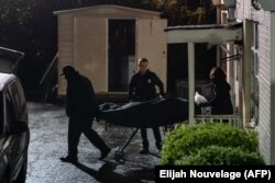 Le personnel du médecin légiste sort un corps sur une civière d'un salon de massage où trois personnes ont été tuées par balle le 16 mars 2021 à Atlanta, en Géorgie.